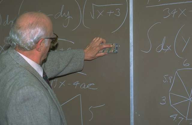 Hombre calvo escribiendo en una pizarra